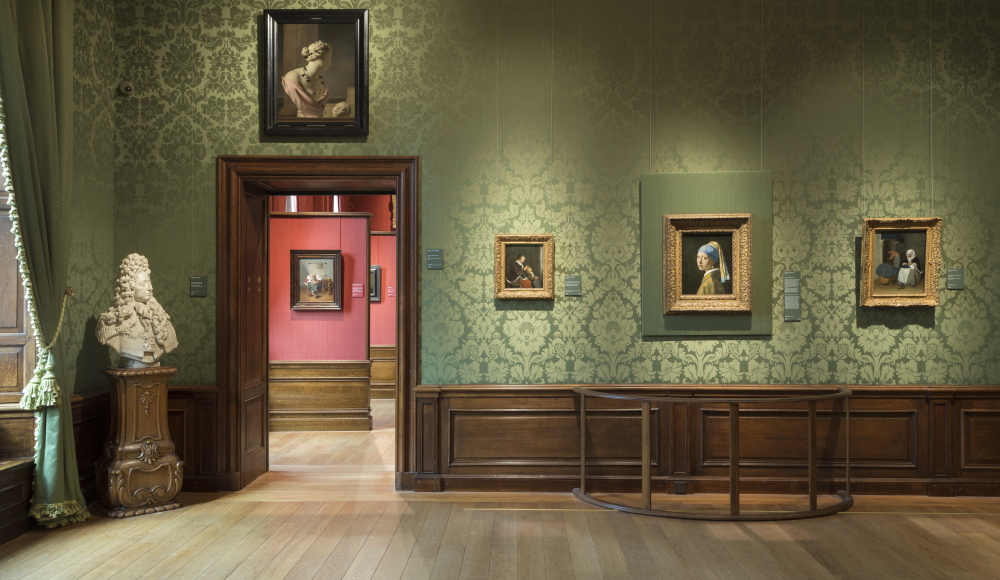 De Vermeer zaal in het Mauritshuis kunstgalerij met schilderijen, waaronder het Meisje met de parel, en een standbeeld. De Vermeer zaal in het Mauritshuis kunstgalerij met schilderijen, waaronder het Meisje met de parel, en een standbeeld.