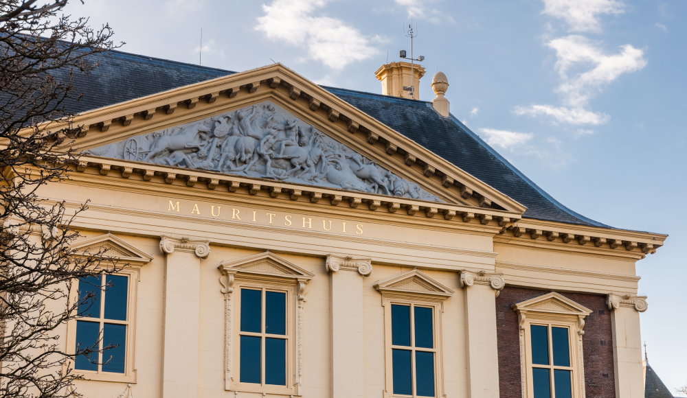 De voorgevel van het imposante zeventiende-eeuwse Mauritshuis tegen een blauwe lucht De voorgevel van het imposante zeventiende-eeuwse Mauritshuis tegen een blauwe lucht
