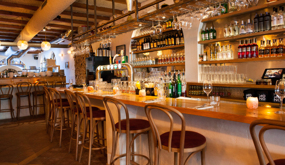 Cozy bar interior with wooden furniture and glassware.