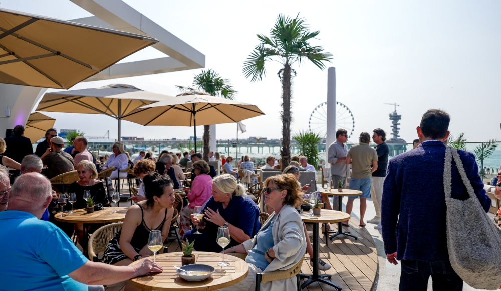 Zonnig terras bij REBORN Whitehouse met uitzicht op zee en Pier