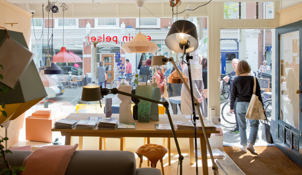Een blik op een winkelinterieur met lampen en mensen buiten. Een blik op een winkelinterieur met lampen en mensen buiten.