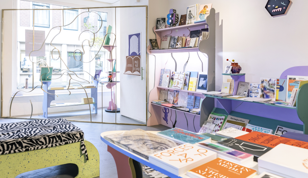 Witte interieur van een boekwinkel met tafels en rekken met boeken en tijdschriften