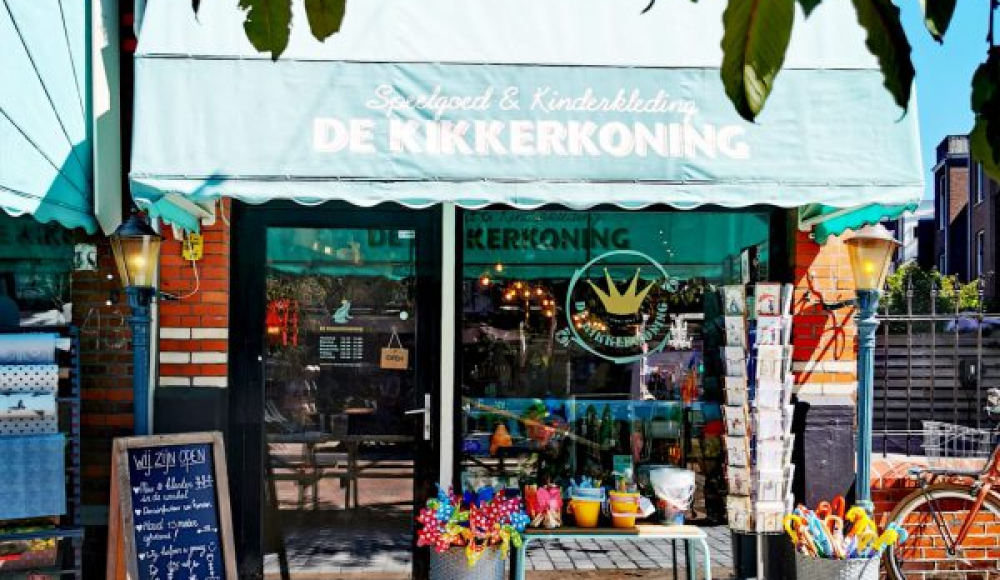 De buitenkant van de kleurrijke kinderwinkel De Kikkerkoning. 