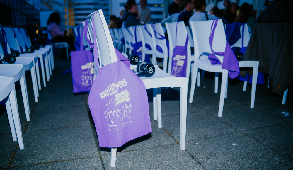 Rijen witte stoelen met paarse tassen en gewichten.
