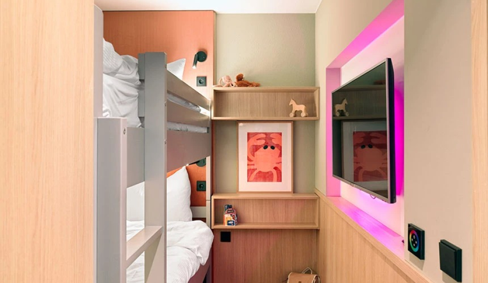 Een moderne hotelkamer met een stapelbed en kunst aan de muur. Een moderne hotelkamer met een stapelbed en kunst aan de muur.