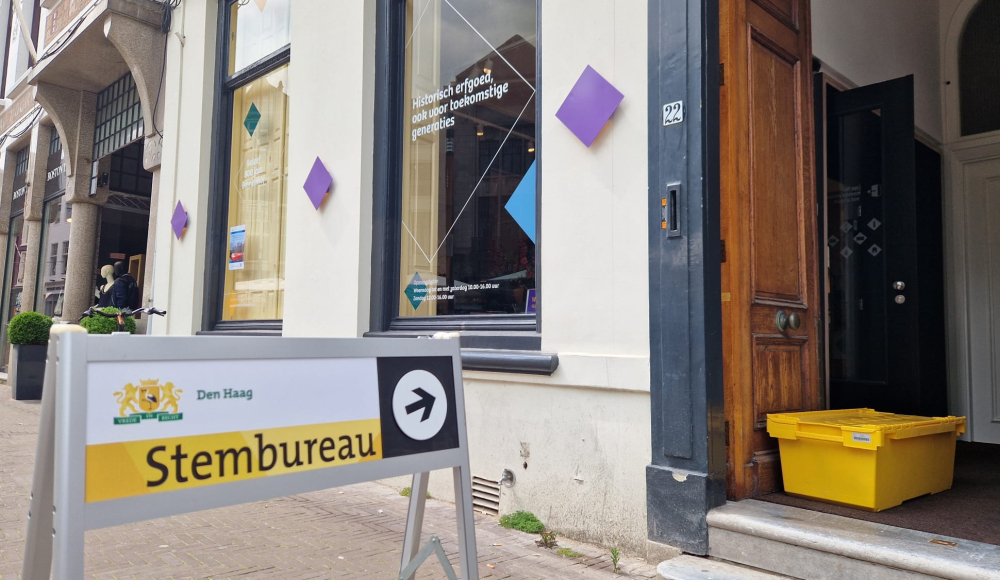 Buitenkant Informatiecentrum Binnenhof Renovatie als stembureau met een bord voor de ingang