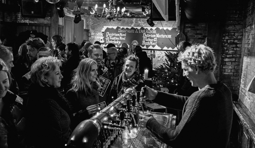 Drukke bar met lachende mensen en bartender Drukke bar met lachende mensen en bartender