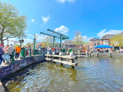 Drukte bij de sluis in Leidschendam, met mensen op de brug, kraampjes en vrolijke sfeer onder een blauwe lucht. Drukte bij de sluis in Leidschendam, met mensen op de brug, kraampjes en vrolijke sfeer onder een blauwe lucht.