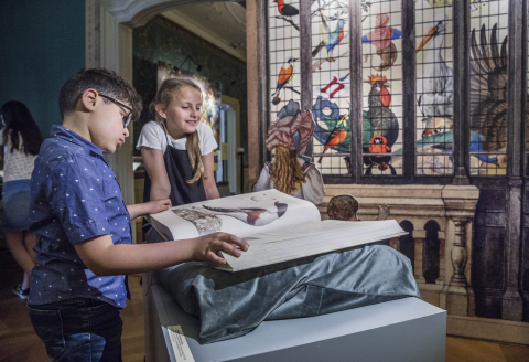Jongen en meisje bladeren in een groot book in BoekenZOO, Huis van het boek