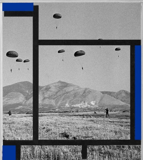 Plusieurs parachutistes descendent dans un champ avec des montagnes en arrière-plan.
