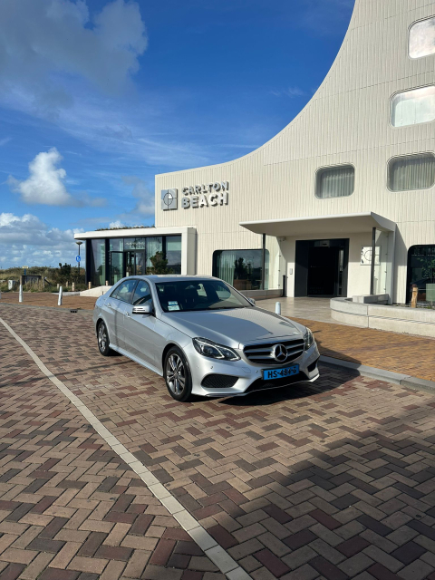 Haagse Taxi Lijn. Een grijze Mercedes sedan staat geparkeerd voor het Carlton Beach hotel.