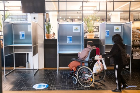 Een vrouw in een rolstoel klaar om te gaan stemmen in toegankelijk stembureau. Een vrouw in een rolstoel klaar om te gaan stemmen in toegankelijk stembureau.