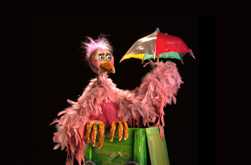 Roze vogelpop met bont parapluutje in de hand