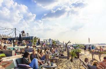 Zonnige stranddag met mensen op loungeterras