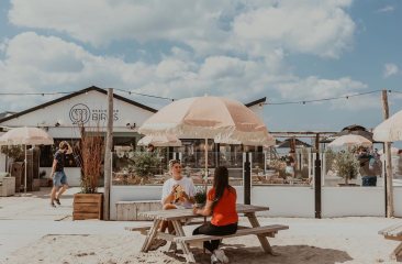 Houten en rieten meubels, jaren 70 parasols op het strand, kortom bij Beachclub Birds beleef je een echte strandvibe.