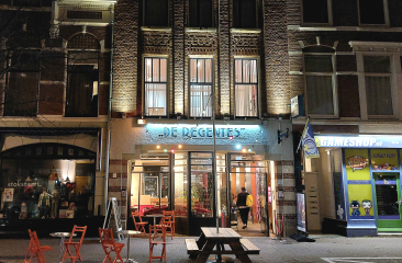 Verlichte voorkant van Theater de Regentes in Den Haag in de avond