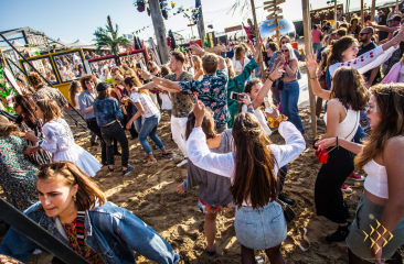 Mensen dansen op het strand bij Beachclub Indigo