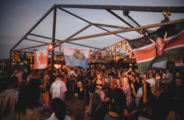 Feestende mensen onder vlaggen op openlucht locatie