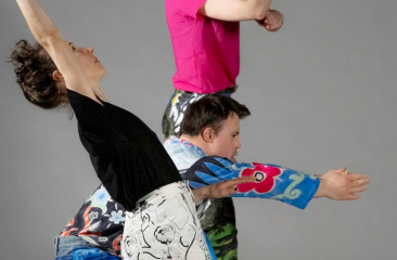 Drie mensen dansen door elkaar in kleurrijke kleren
