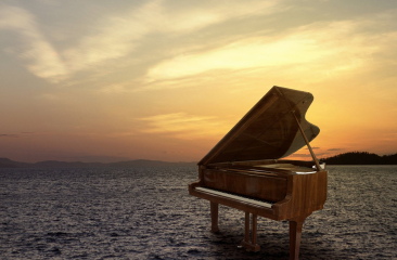 Een piano in het water met zonsondergang op de achtergrond