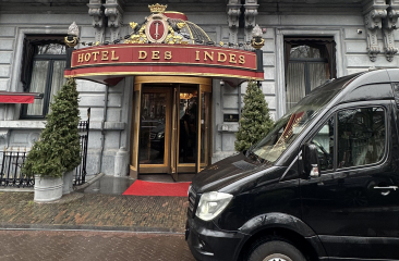 Luxe Mercedes Sprinter bus van DG Luxury tours voor de deur van Hotel Des Indes in Den Haag