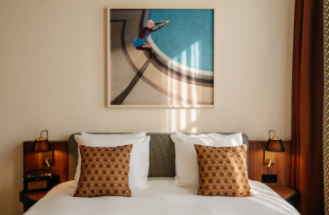 Deluxe Double Room met een bed met daarop kussens en warme houten accenten