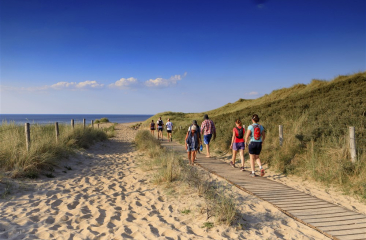 Groep mensen wandelt door de duinen van Scheveningen