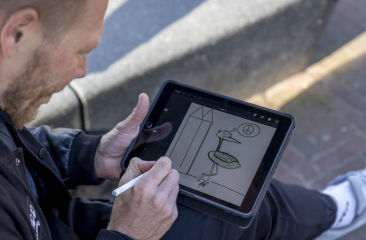 Merk ambassadeur Pat Smith krabbelt op een touchscreen een ooievaar en zijn denkbeeld van Vrede & Recht.