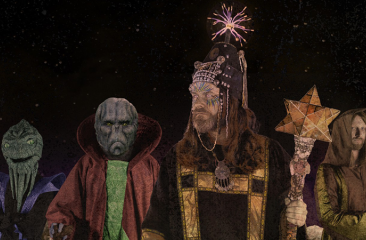 Band Henge in flashy outfits en de maan op de achtergrond wat past bij hun act als space formatie.