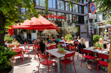 Het terras van Vapiano een het Buitenhof in Den Haag met rode stoeltjes en rode parasols Het terras van Vapiano een het Buitenhof in Den Haag met rode stoeltjes en rode parasols