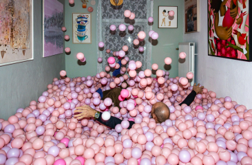 Volwassenen in kamer vol roze ballen