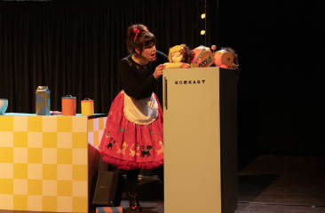 Vrouw in theaterkeuken opent 'koekast' met poppen (c) Laros & de jong beeldmakerij 
