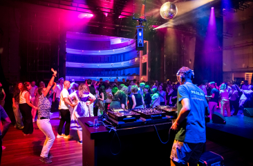 Dansende mensen met DJ achter draaitafel