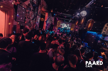Drukke dansvloer in het Paardcafé in Den Haag, met feestende mensen, kleurrijke verlichting en een levendige sfeer. Drukke dansvloer in het Paardcafé in Den Haag, met feestende mensen, kleurrijke verlichting en een levendige sfeer.