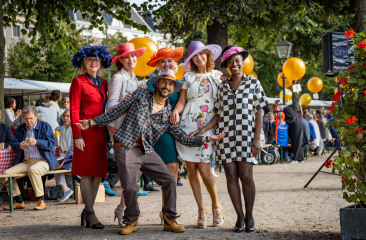 Groep mensen in kleurrijke outfits en hoeden ©Jelle Mes