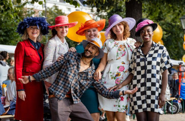 Bezoekers in kleurrijke outfits en hoedjes op Prinsjesfestival