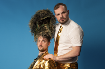 Twee mannen in goudkleding, één met helm van gras