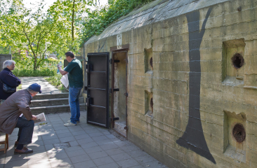 Buitenkant van het Atlantikwall Museum Scheveningen waar mensen luisteren naar de gids