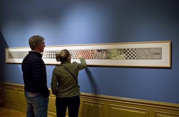 Man en vrouw kijken naar één van de kunstwerken van M.C. Escher