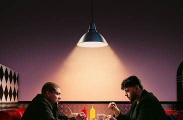 Twee mannen eten stil in een retro diner
