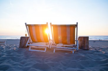 Twee vrolijk gekleurde ligstoelen om heerlijk in te relaxen bij Strandpaviljoen Zuid op het stille strand