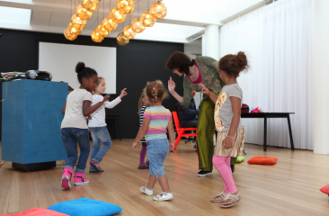 Kinderen dansen samen met een volwassene in een lokaal