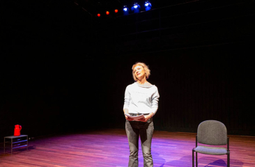 Vrouw op toneel met script in spotlight