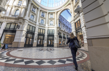 Vrouw loopt door het ronde deel met de mooie terrazzovloer van de Passage in Den Haag. 