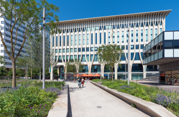 Architecture moderne avec des arbres et des personnes sur le chemin.