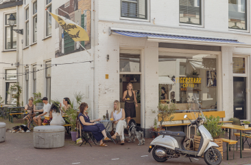 Mensen zitten op het terras van Gershark Coffee in Den Haag.