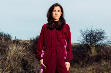 Vrouw met lange haren staat in duingras