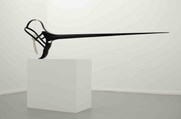 A long, black abstract sculpture stands on a white pedestal.
