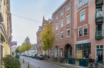 Street view with bicycles, trees, and buildings in The Hague.