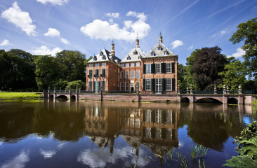 Een historisch gebouw met een spiegeling in het water.